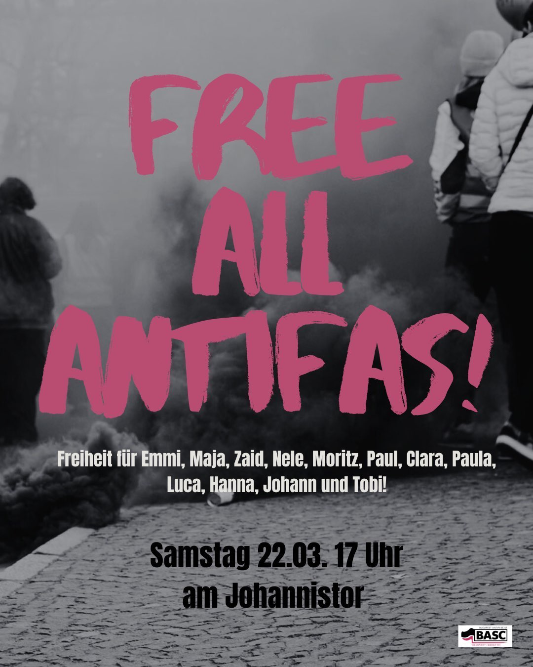 Das Bild zeigt ein Plakat mit einem Aufruf zur Freilassung von Antifaschisten. Der Hintergrund ist in Schwarz-Weiß gehalten und zeigt eine Straßenszene mit mehreren Personen, die sich auf einem Kopfsteinpflasterweg befinden. Einige der Personen tragen Mützen und Jacken, was darauf hindeutet, dass es kalt sein könnte. Im Hintergrund sind Rauchschwaden zu sehen, die möglicherweise von einer Demonstration oder einem ähnlichen Ereignis stammen. Der Text auf dem Plakat ist in leuchtendem Rosa geschrieben und lautet: "FREE ALL ANTIFAS!" Darunter steht in kleinerer Schrift: "Freiheit für Emmi, Maja, Zaid, Nele, Moritz, Paul, Clara, Paula, Luca, Hanna, Johann und Tobi!" Unter diesem Text wird das Datum und die Uhrzeit des Events angegeben: "Samstag 22.03. 17 Uhr am Johannistor". In der rechten unteren Ecke des Plakats befindet sich ein Logo mit der Aufschrift "BASC".